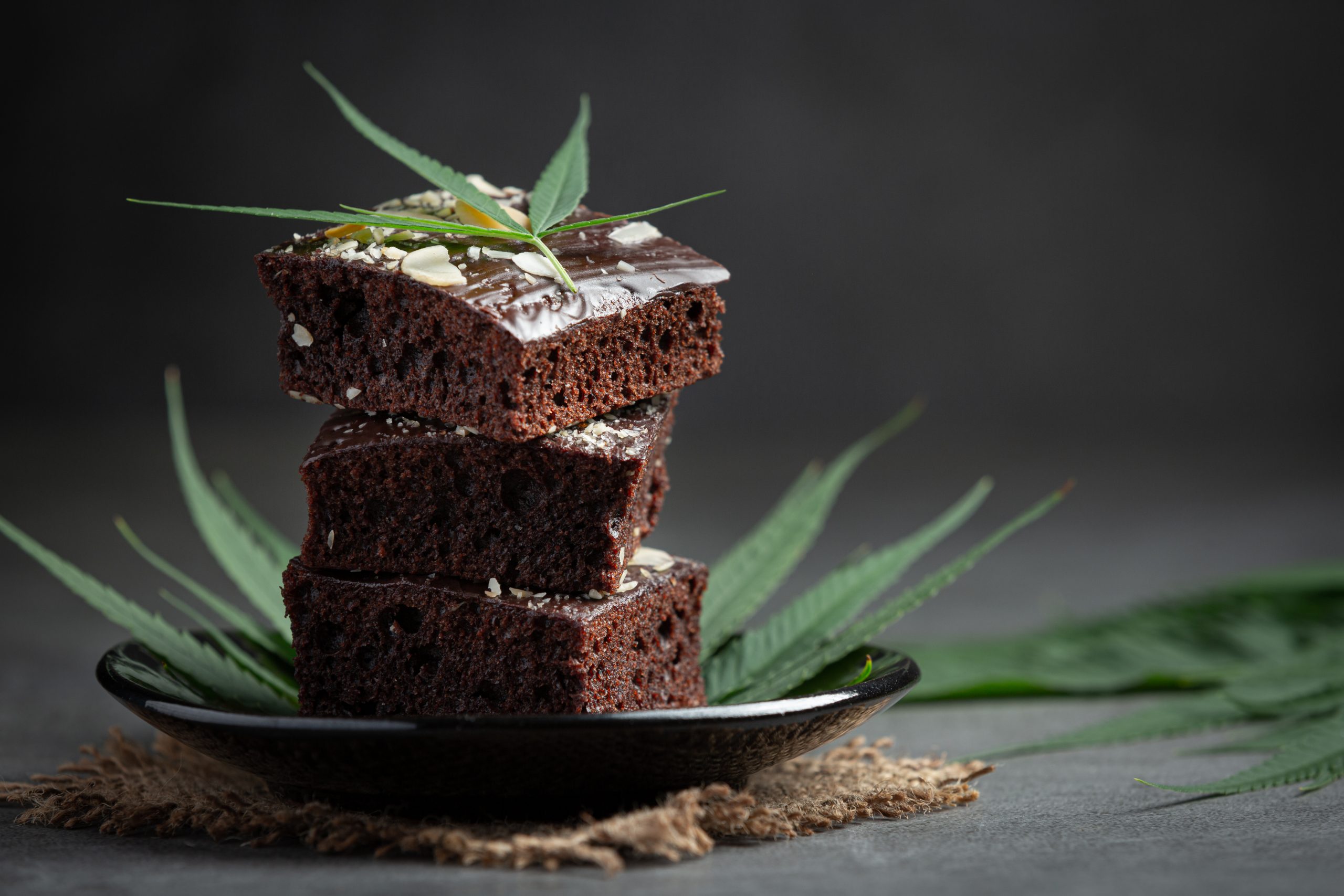 cannabis brownies and cannabis leaves put on black plate